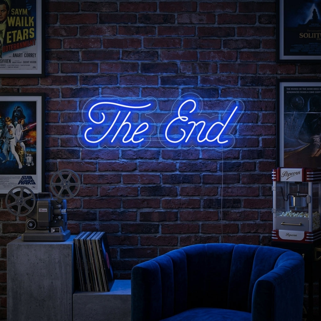 The End neon sign mounted on a dark wall above a cozy seating area in a home theater, glowing in blue text with white film reel icons.