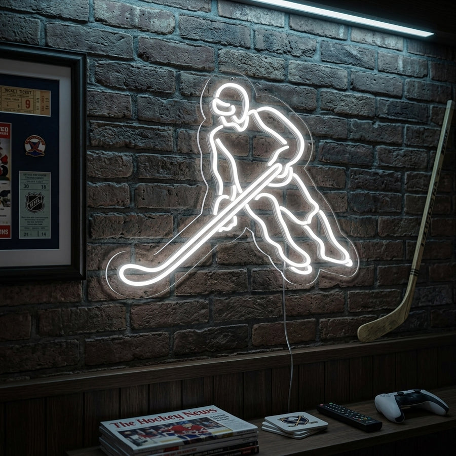 Illuminated neon sign depicting a dynamic hockey player figure in action, mounted on a brick wall in a cozy living room setting above a sofa.