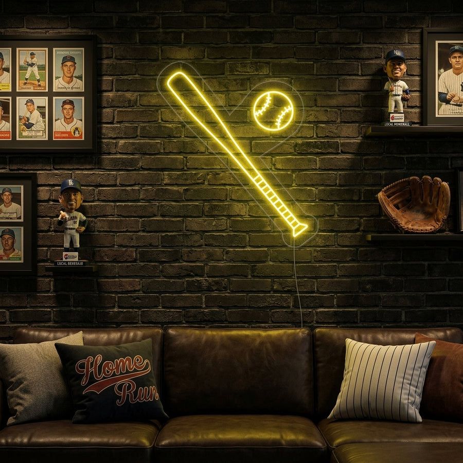 A vibrant glowing neon sign depicting a baseball bat hitting a ball, mounted on a brick wall in a rustic game room setting.