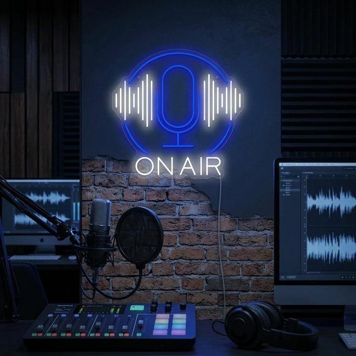 Vibrant 'Podcast On Air' neon sign glowing red on a recording studio wall with acoustic foam panels and professional microphone.