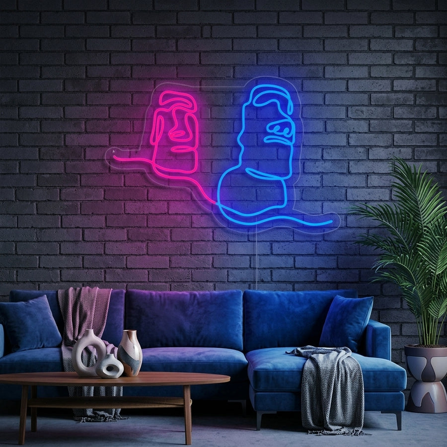 A lifestyle photo showing the glowing Moai Easter Island Giant Statue Chile neon sign mounted on a textured wall in a modern room setting.