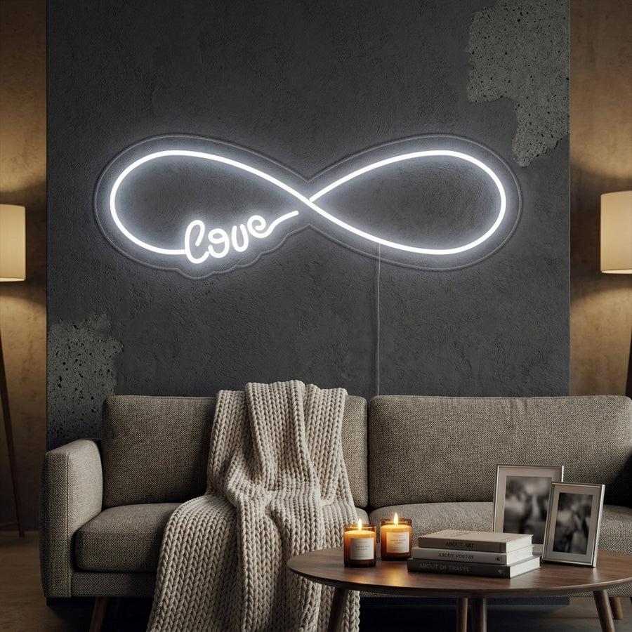 A cozy bedroom with the glowing red Infinity Love neon sign mounted on a textured wall above the bed with pillows.