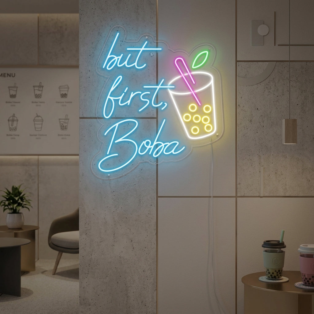 A vibrant 'But First Boba' neon sign glowing brightly on a wall in a trendy cafe setting.