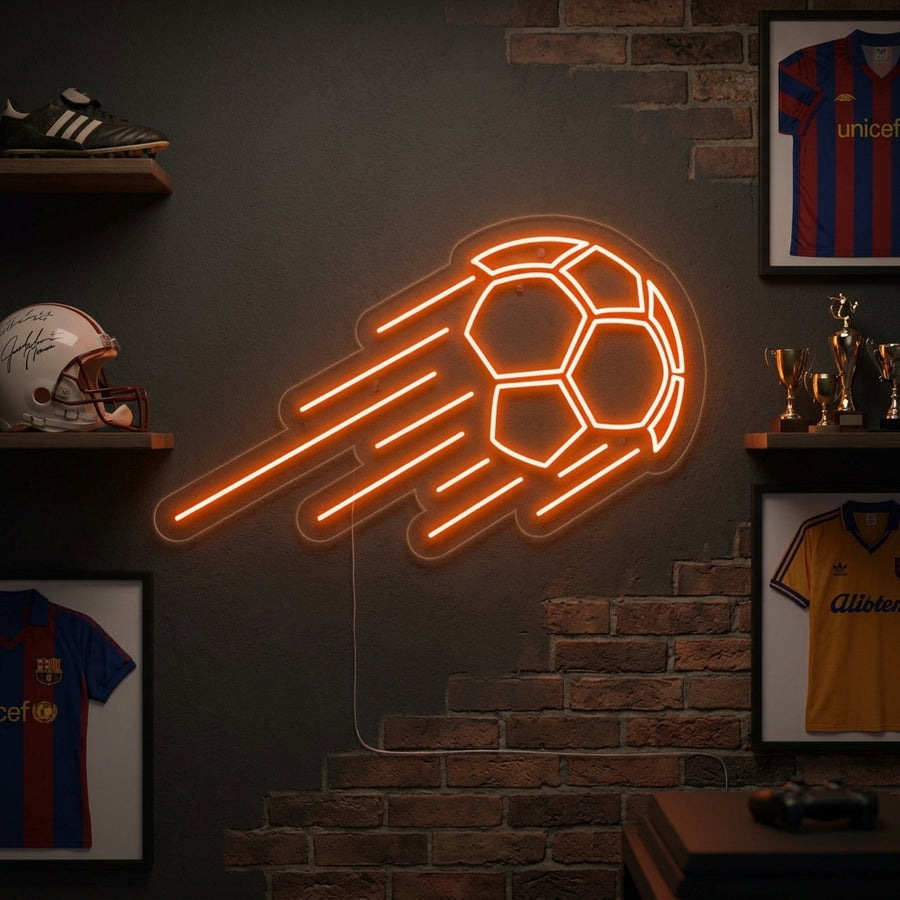 Vibrant glowing neon sign depicting a traditional white and black panelled football in motion, casting a warm orange light on a textured brick wall within a cozy living space.
