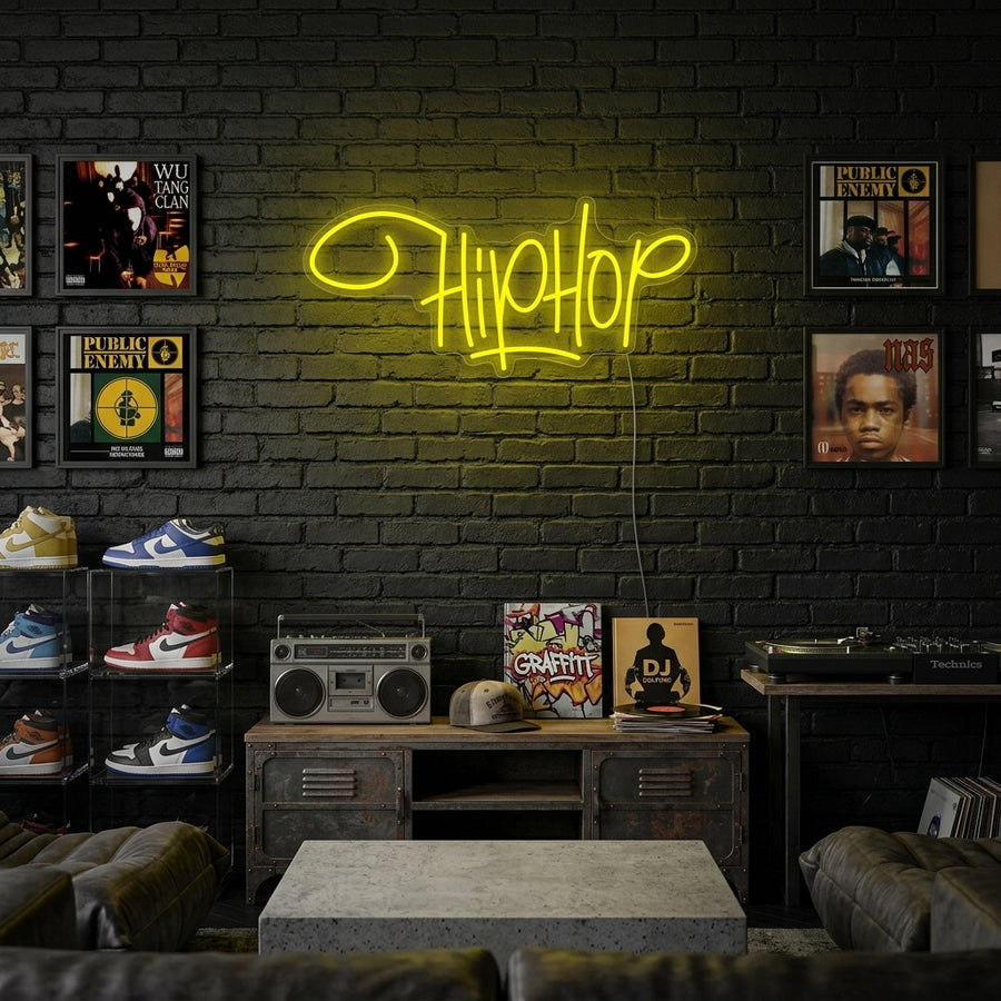 A glowing 'Hip Hop Rap Music' neon sign displayed on a dark brick wall in a lifestyle setting, illuminating a record player and urban decor.