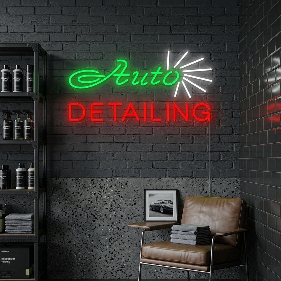 Illuminated 'Auto Detailing Shop' neon sign with text details 'WASH WAX VACUUM' hanging in a professional garage setting above a polished black car.
