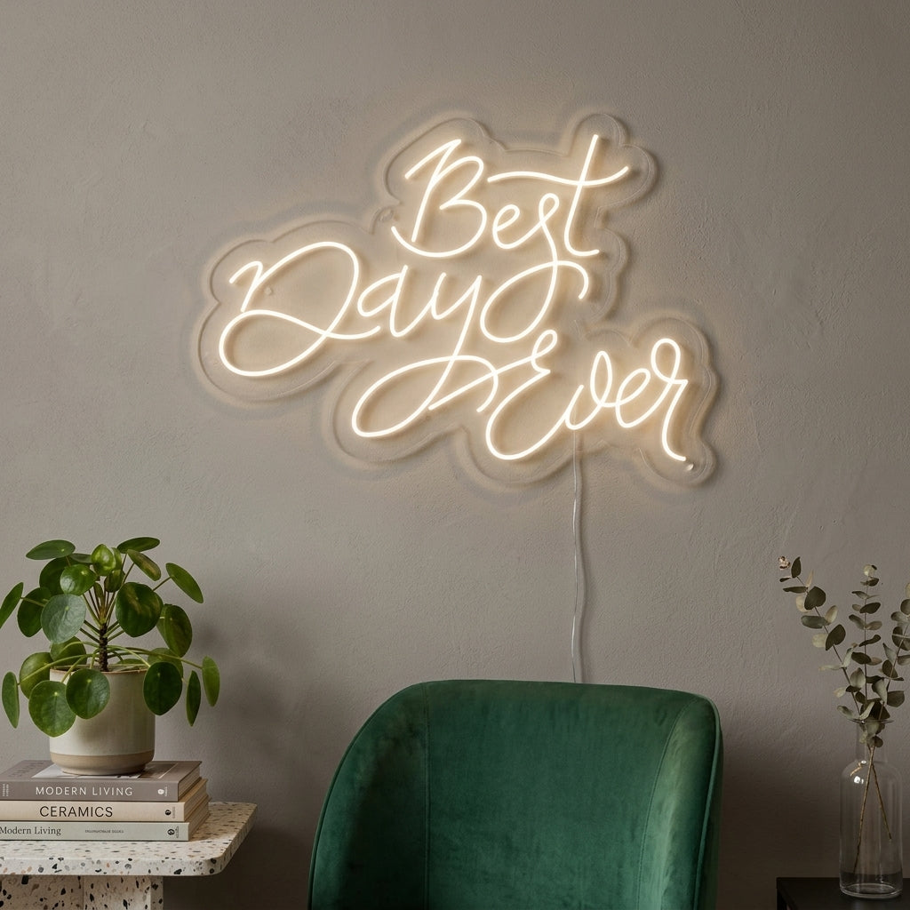 A "Best Day Ever" neon sign glowing warmly above an upholstered chair in a modern living space.