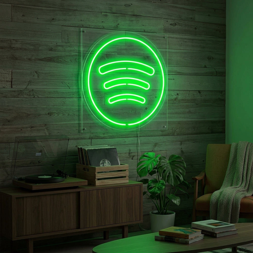 A vibrant Spotify logo neon sign glowing bright green on a modern, textured wall, casting light on a desk with audio equipment and plant decor in a cozy room.