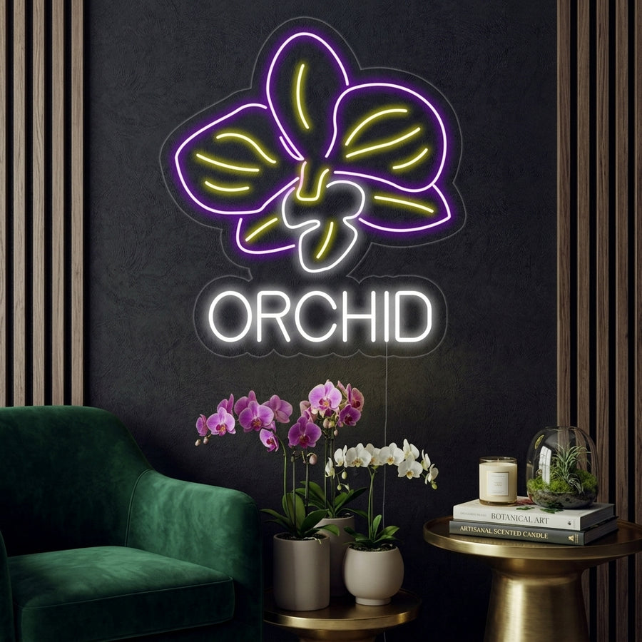 A lifestyle photo of a lit white Orchid Flower neon sign mounted on a textured living room wall above a sofa with green plants and warm ambient lighting.