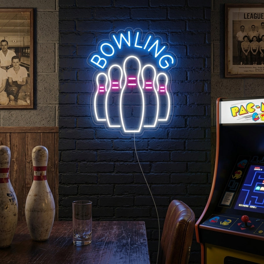 "Bowling Bottles" neon sign illuminated on a rustic brick wall above comfortable seating, glowing brightly in a game room setting.