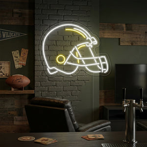 A glowing neon sign of an American football helmet hanging above a sofa in a modern sports-themed game room.