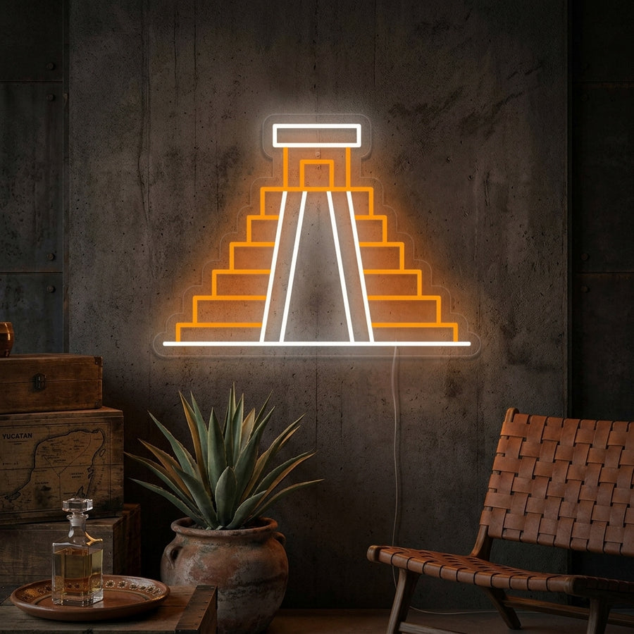 A lifestyle shot of the Mexico Chichen Itza neon sign glowing warmly on a decorated wall in a cozy room.