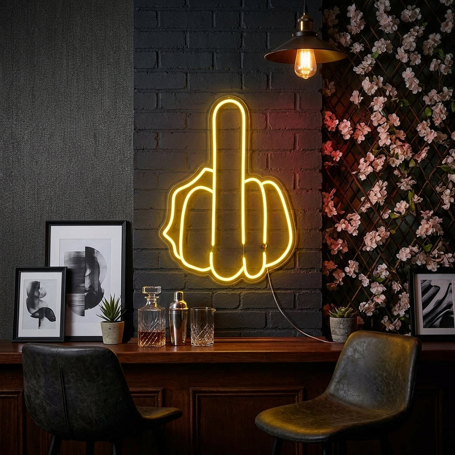 A hand gestures the middle finger in a glowing neon sign style, set against a dark wall in a cozy room.