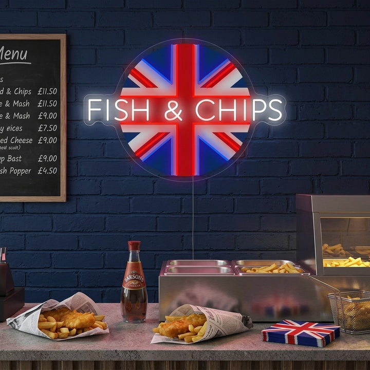 A glowing UK Fish & Chips neon sign showing a fish, chips, and 'Great British Tradition' text mounted on a rustic wood panel wall in a cozy shop setting.