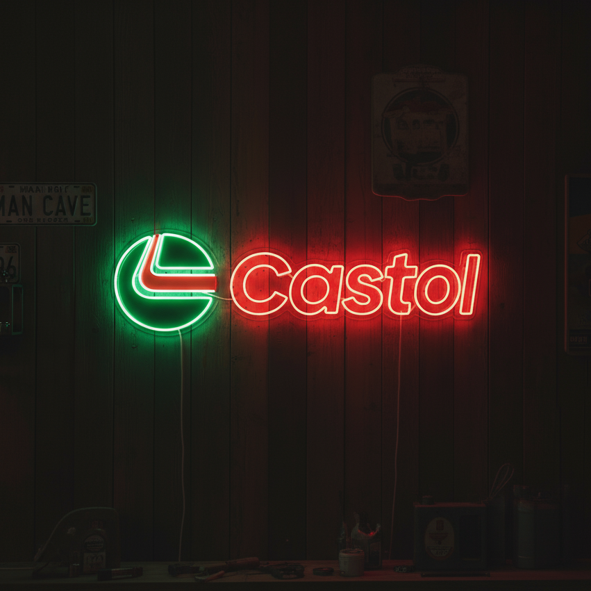Red and green Castrol logo neon sign mounted in a busy garage workshop setting.