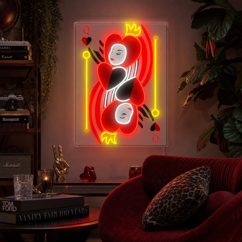 An illuminated Queen of Hearts playing card neon sign glowing red over a professional poker table set with chips in a dimly lit game room.