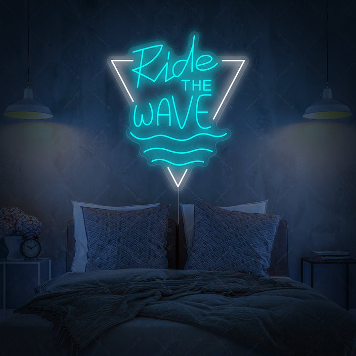 A close-up view of the illuminated 'Ride The Wave' neon wall decor, showcasing the vibrant script and clean design against a stylish, minimalist background.