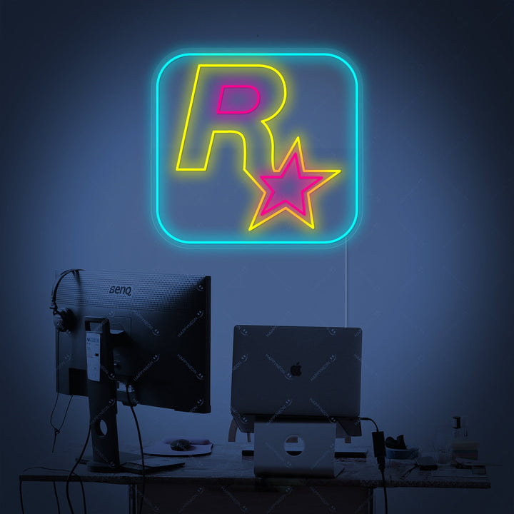 The iconic Rockstar Games logo depicted as a vibrant yellow neon sign with visible acrylic backing and electrical cord.