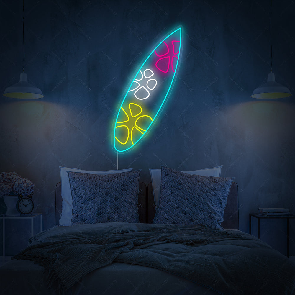 Close-up of a blue and white surfboard neon wall decor hanging above a rustic wooden bedside table.