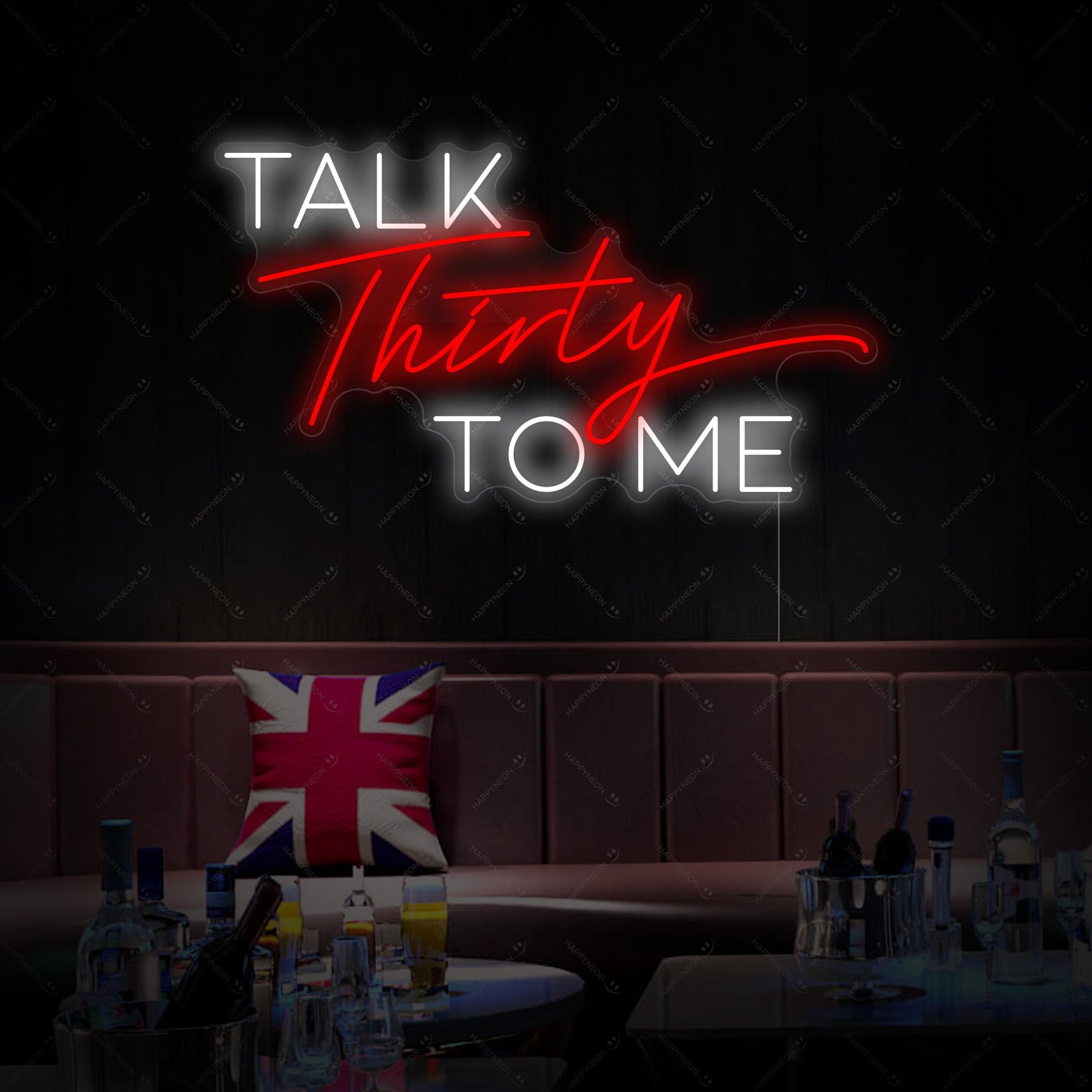 The 'Talk Thirty To Me' neon sign glowing brightly on a textured wall in a home environment.