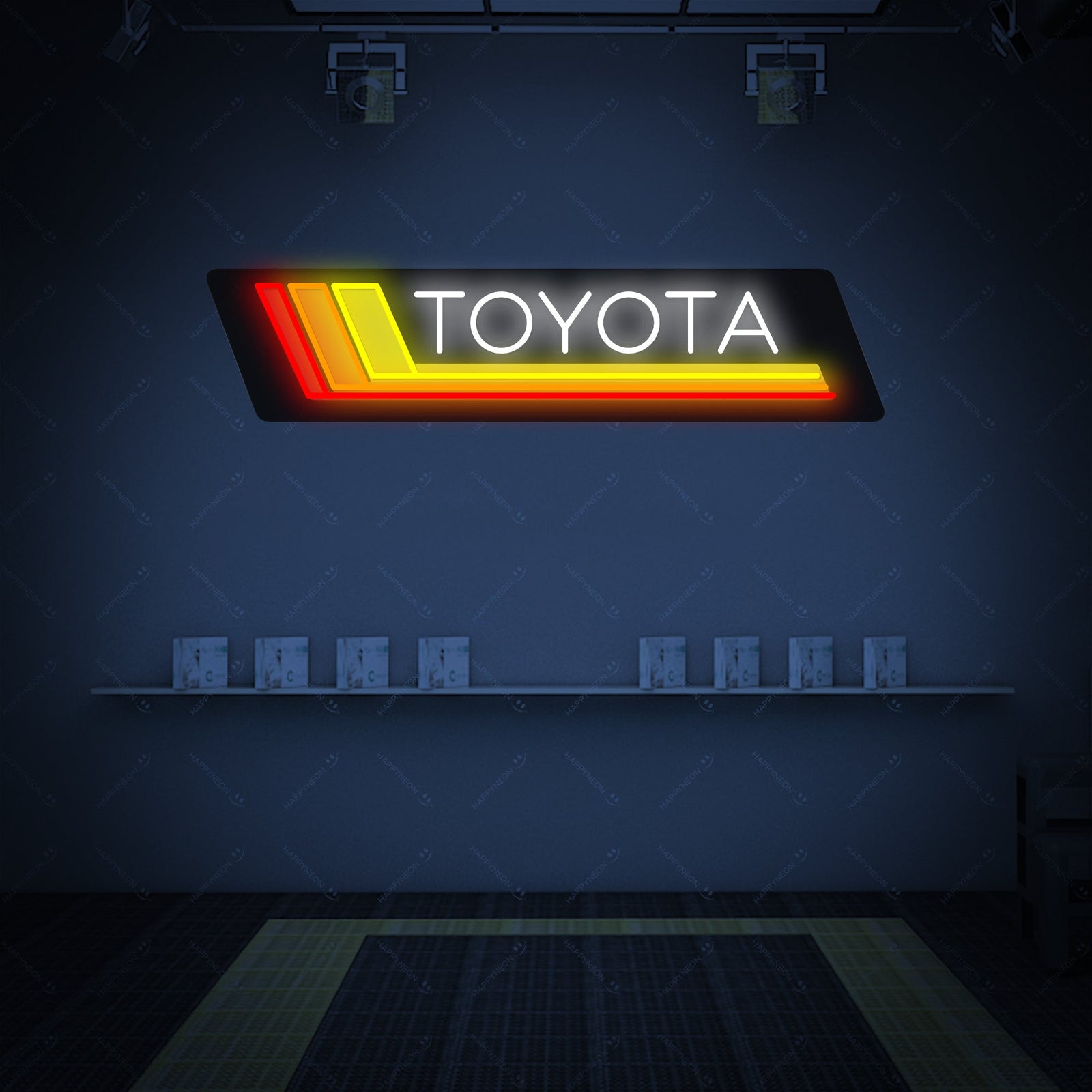 A glowing 'TOYOTA' neon sign with red tubing mounted on a wood-paneled wall above a desk with various automotive collectibles in a modern room, with visible wall glow.