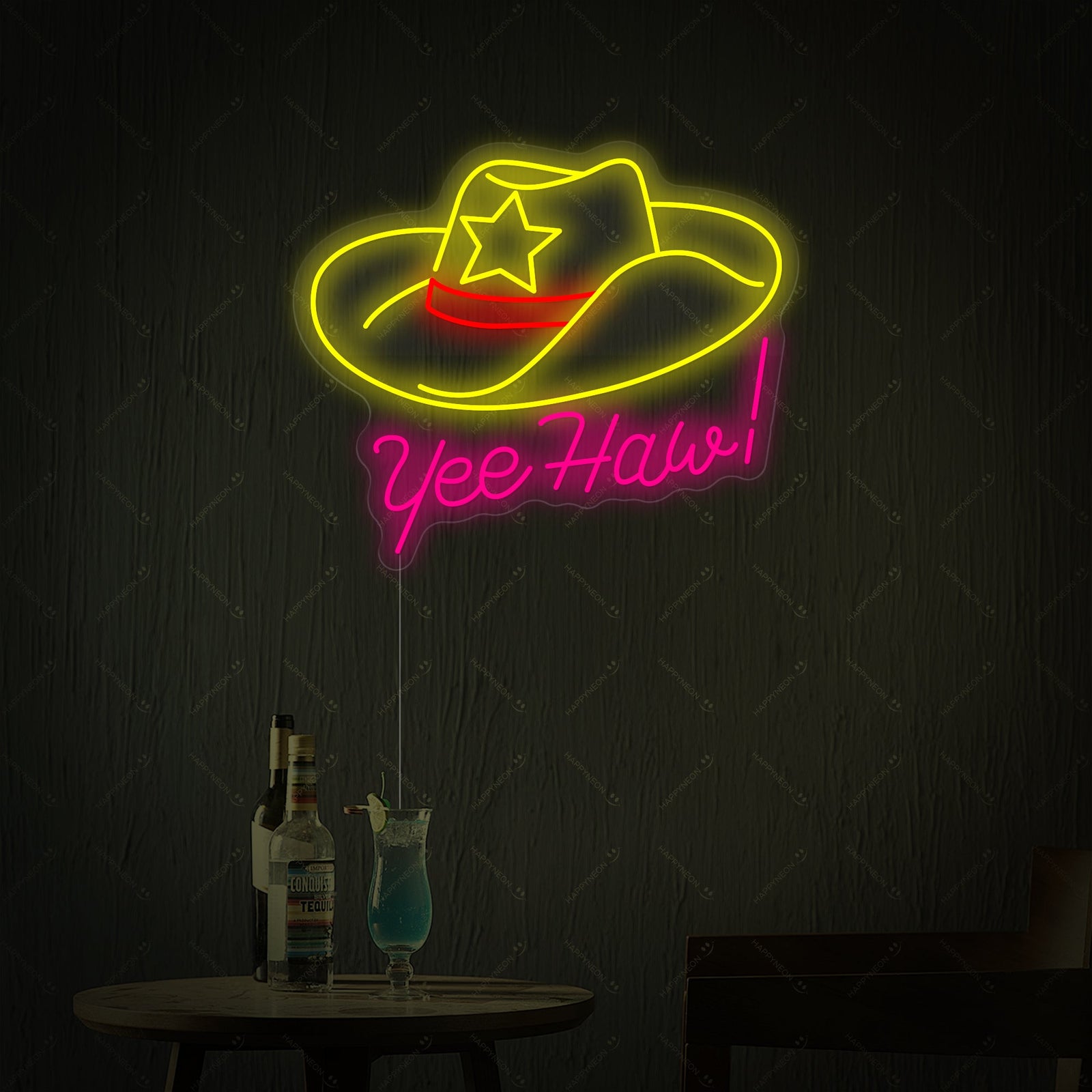 A digital rendering of the 'Yeehaw' neon sign showcasing its distinct neon tubing, an acrylic backboard, and a power cord, styled next to a table with drinks.