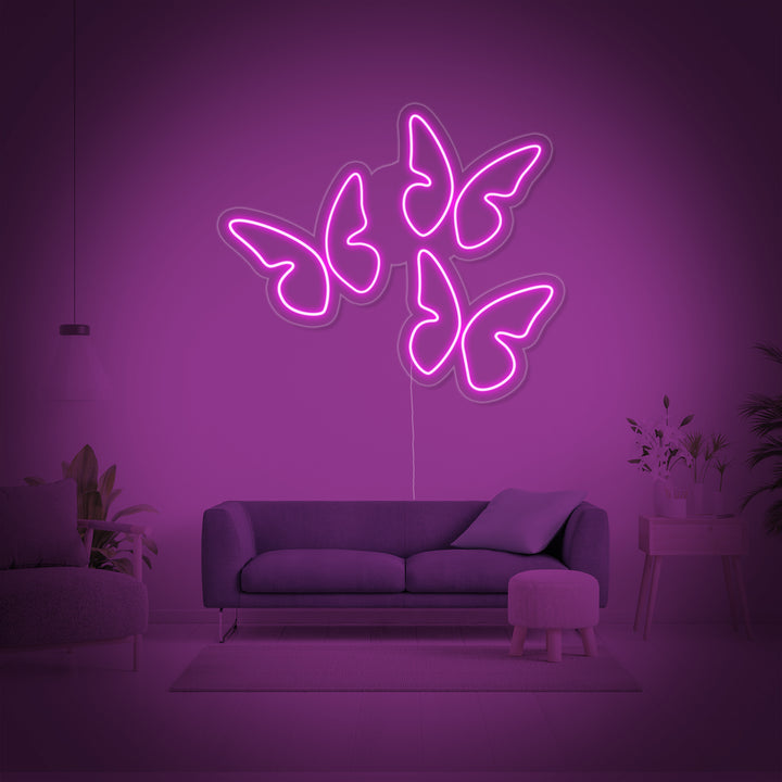 Handcrafted LED neon sign featuring three colorful butterflies, mounted on an acrylic backing, glowing with warm light.