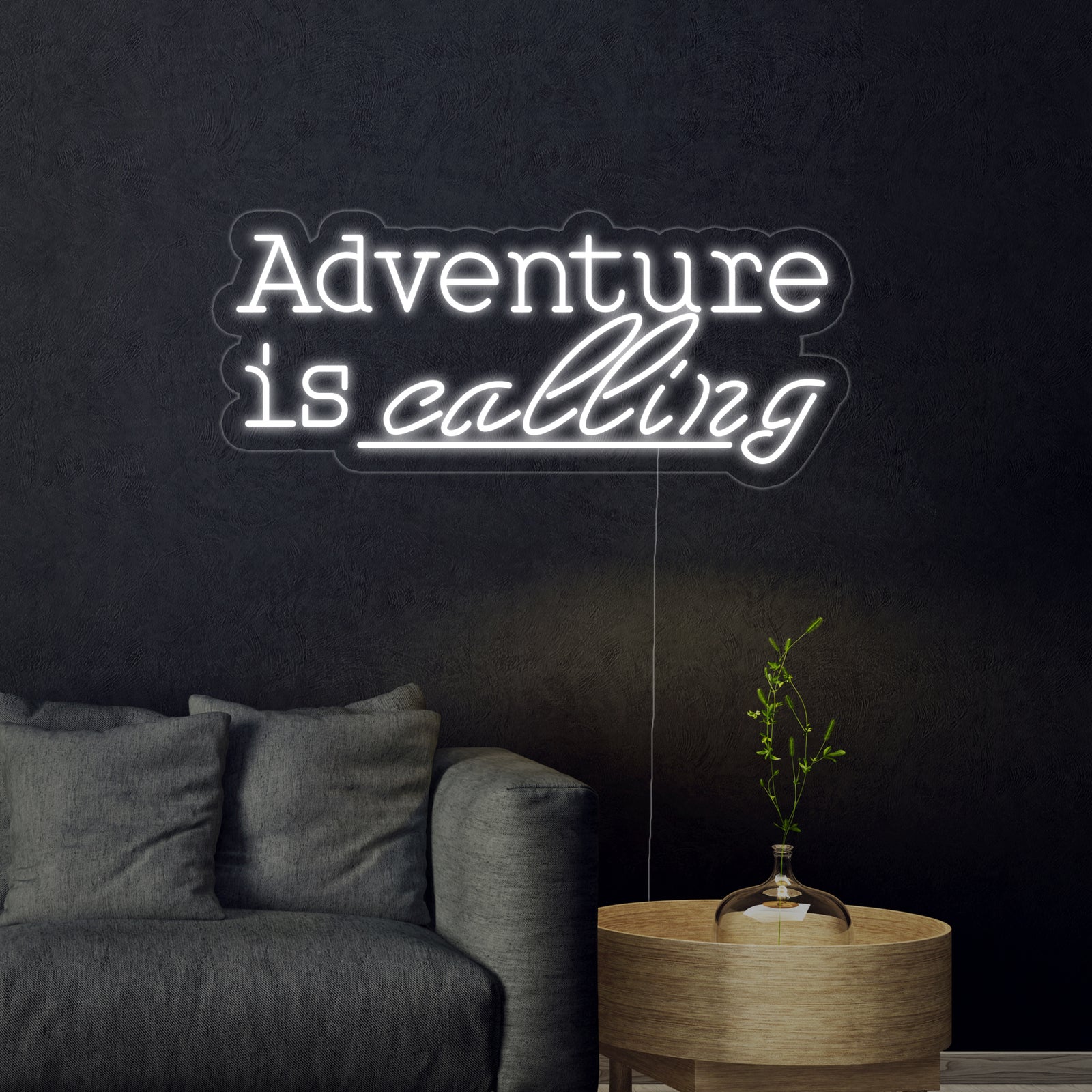 A close-up of the handcrafted 'Adventure is Calling' neon sign on its acrylic backing.