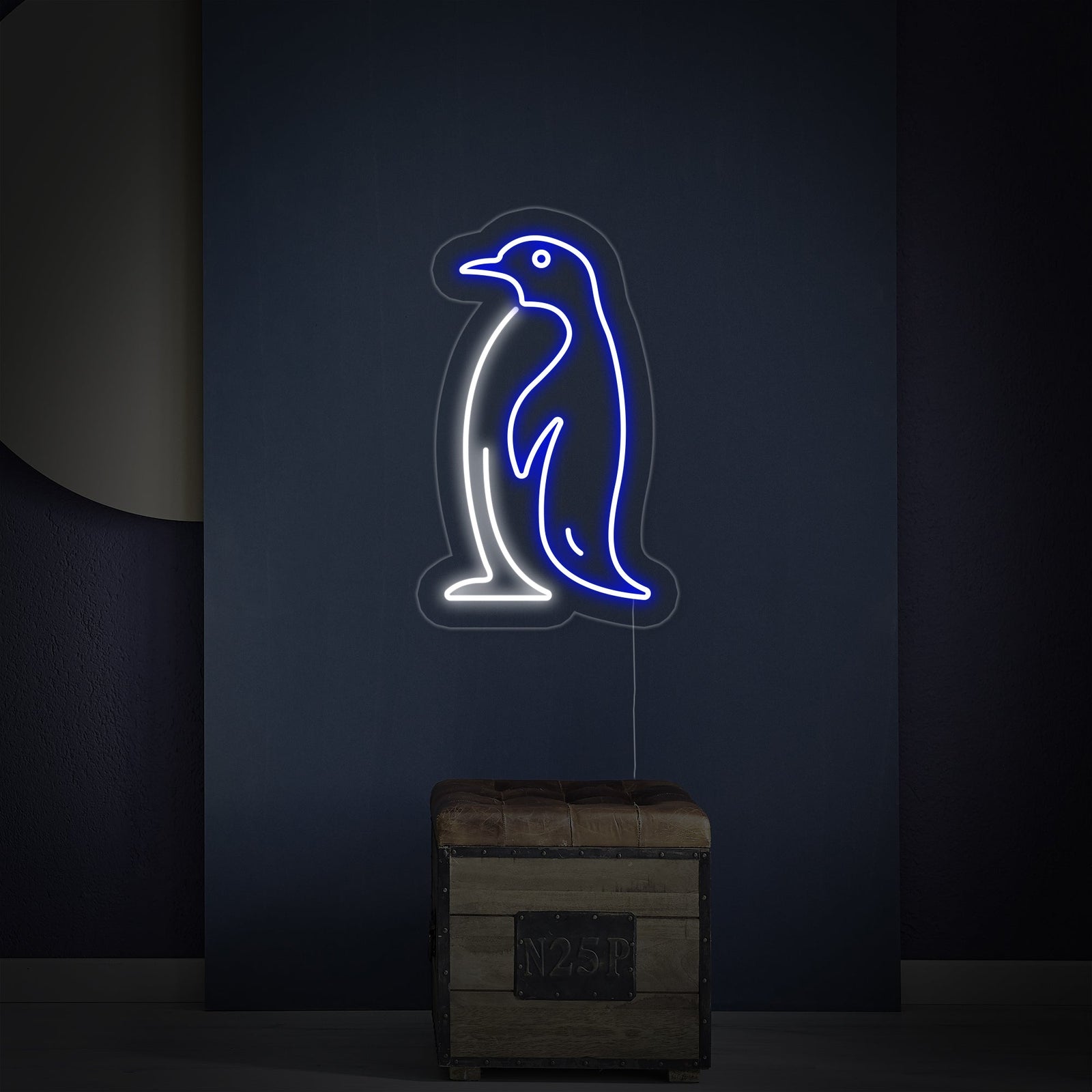 A glowing penguin neon sign with an acrylic backing and a visible black power cord.