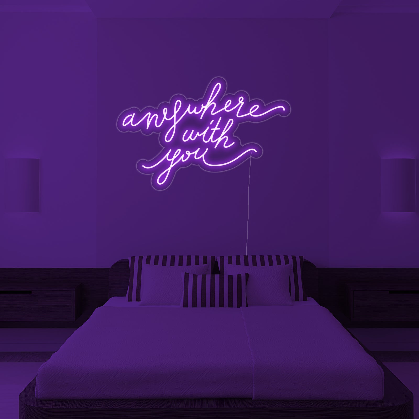 The 'Anywhere With You' neon wall decor sign positioned above a bed in a cozy, stylish bedroom setting, casting a warm ambient light.