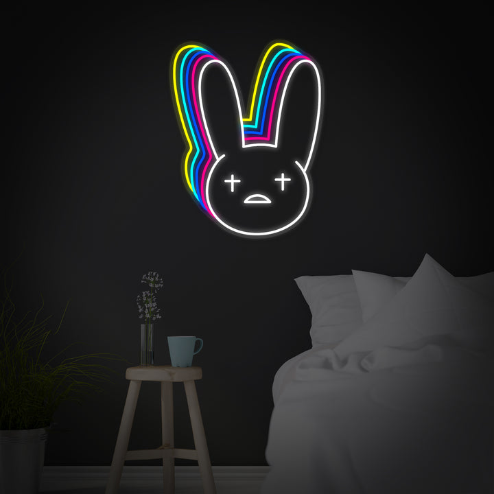 A glowing graphic design of the Bad Bunny rapper neon sign against a dark, textured wall backdrop.