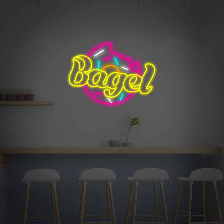 A graphic design mockup of a hand-bent neon sign spelling out 'BAGEL' with a stylistic bagel icon above it, showing potential mounting on a dark background.