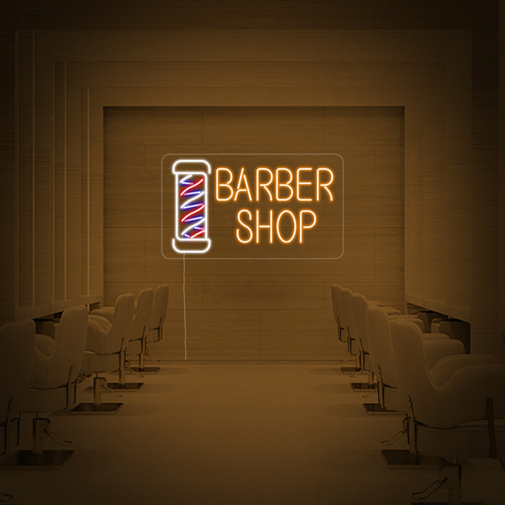 A close-up photograph of the 'Barber Shop' neon sign showcasing the detailed craftsmanship, glowing neon tubes, and clear mounting backboard against a stylish interior background.