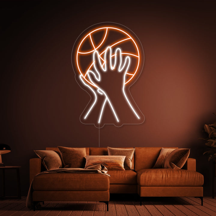 A neon light depicting a basketball player shooting, glowing orange and white in a modern bedroom setting.