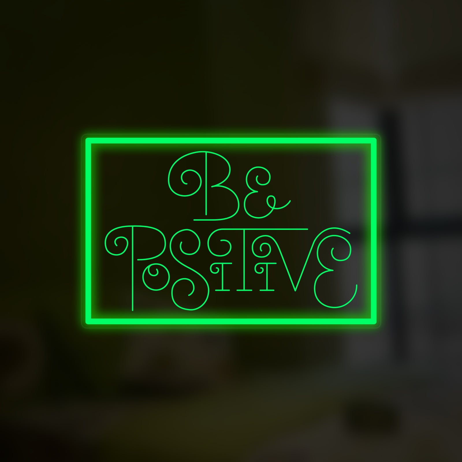 Close-up detail of 'Be Positive' script neon sign glowing