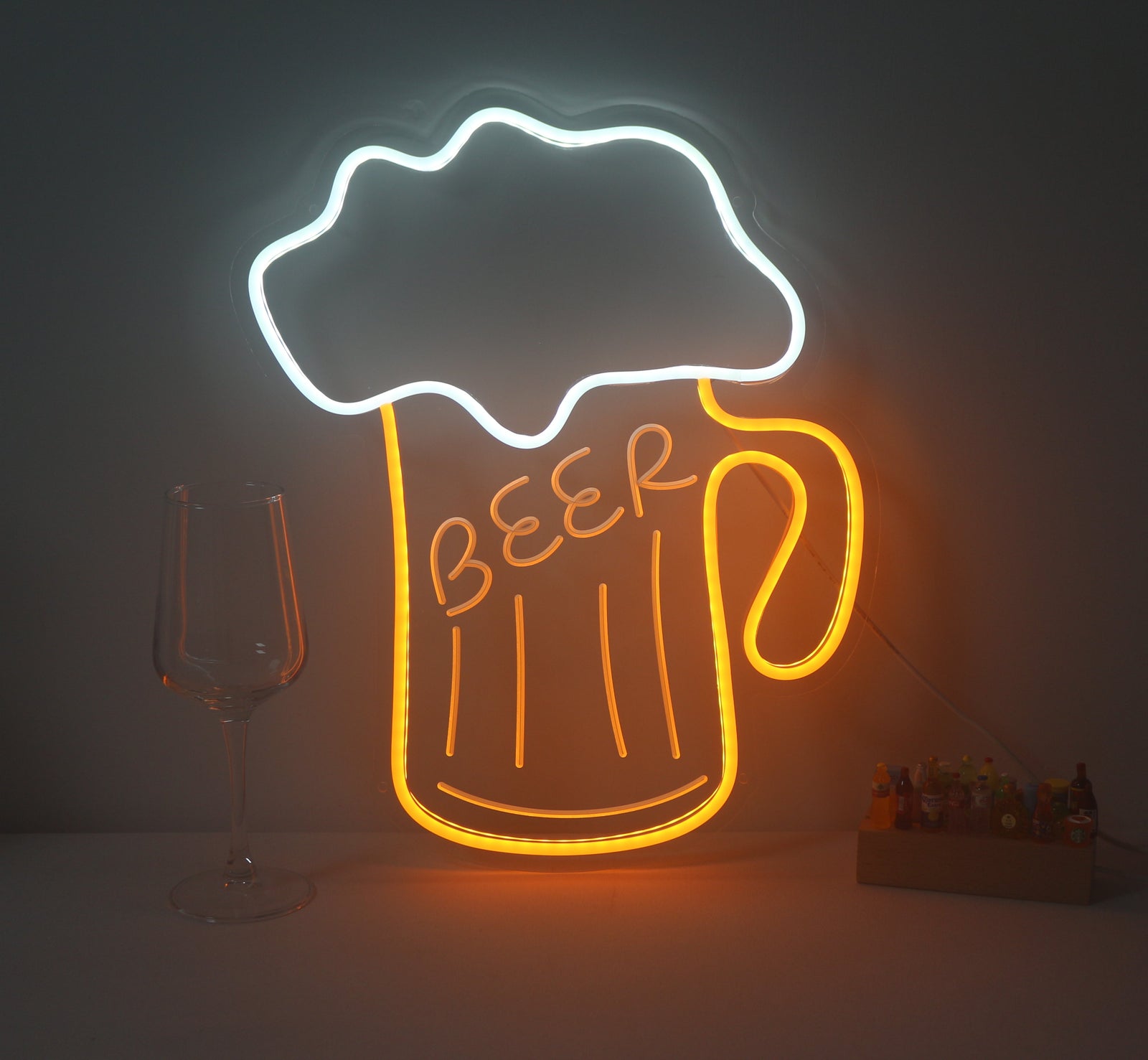 A physical Beer Drinking Mini Neon Sign glowing blue and yellow against a brick wall, featuring an image of a beer mug.