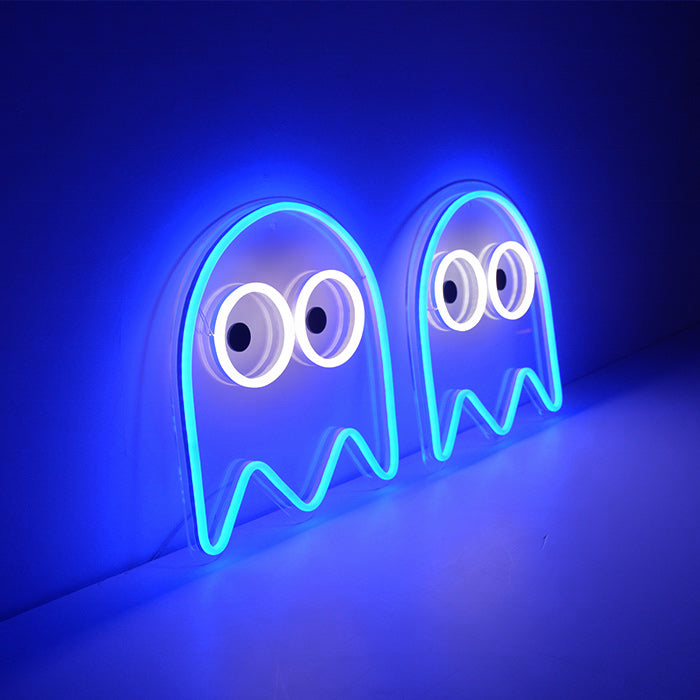 A vibrant blue ghost-shaped neon sign glows intensely, casting a cool blue light on the dark surface below it, perfect for a gamer's room or bedroom decor.