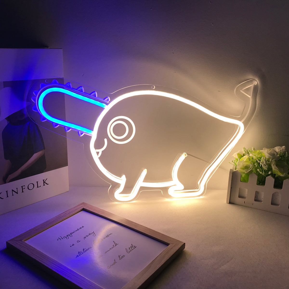 A pink anime character neon sign, depicting Hitori Gotoh from Bocchi the Rock!, glowing on an acrylic backing in a room setting.