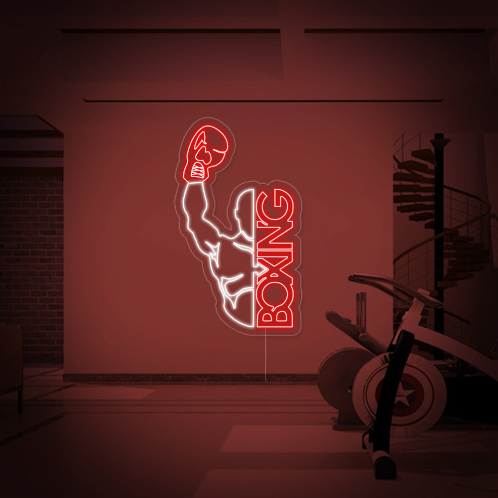 Close-up of a Boxing Man neon sign with glowing outlines mounted on a clear backer against a gym setting.