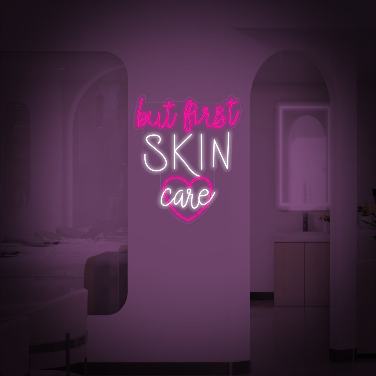 A brightly lit pink 'But First Skin Care' neon wall sign mounted on a clean white surface.