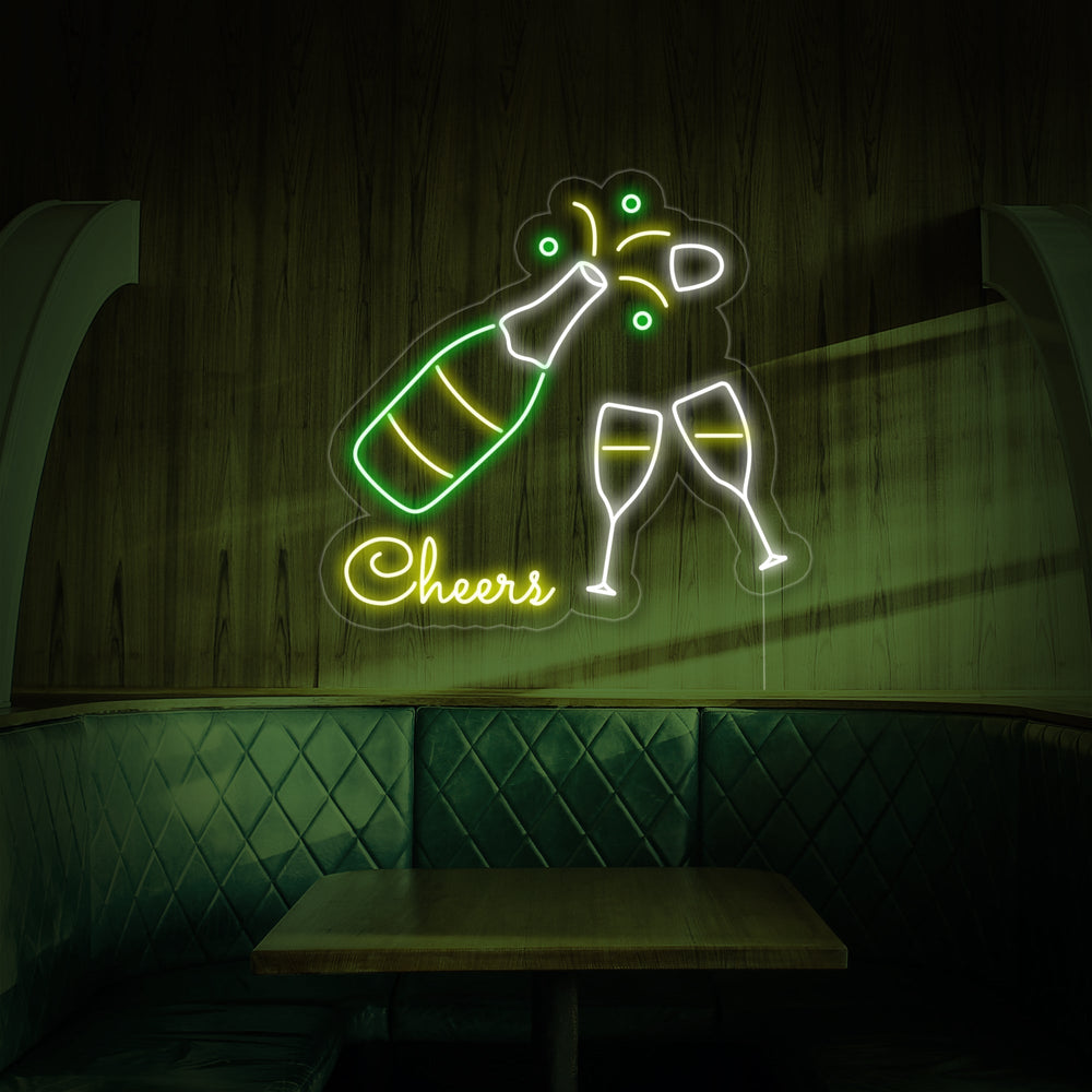 Studio product shot of the 'Champagne Bottle Glasses Cheers' neon sign displaying the details of the neon tubes and clear acrylic backing, set against a blurred background.