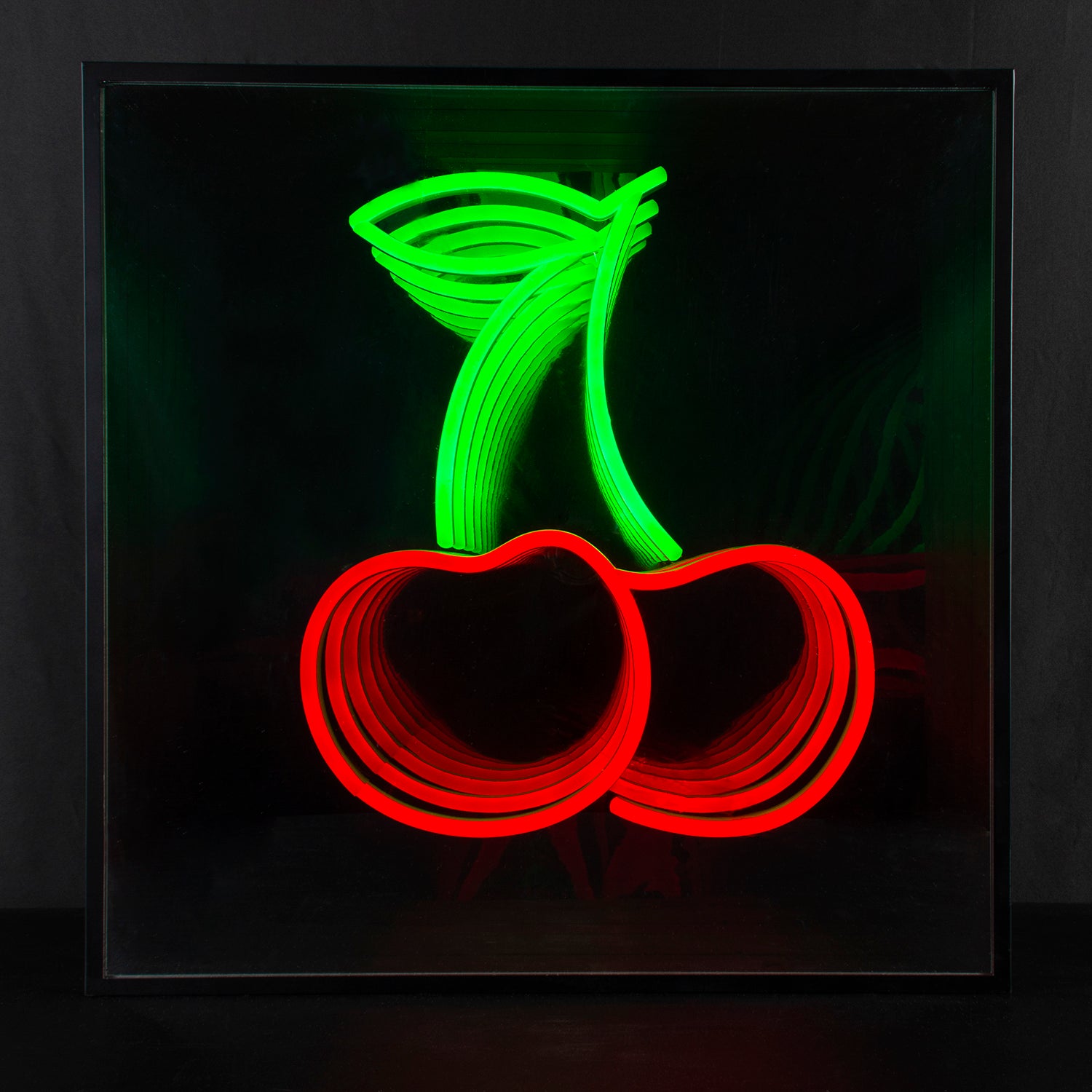 A physical photograph of the "Cherry" 3D Infinity Neon Sign glowing against a plain background, showing the fruit design and endless depth effect.