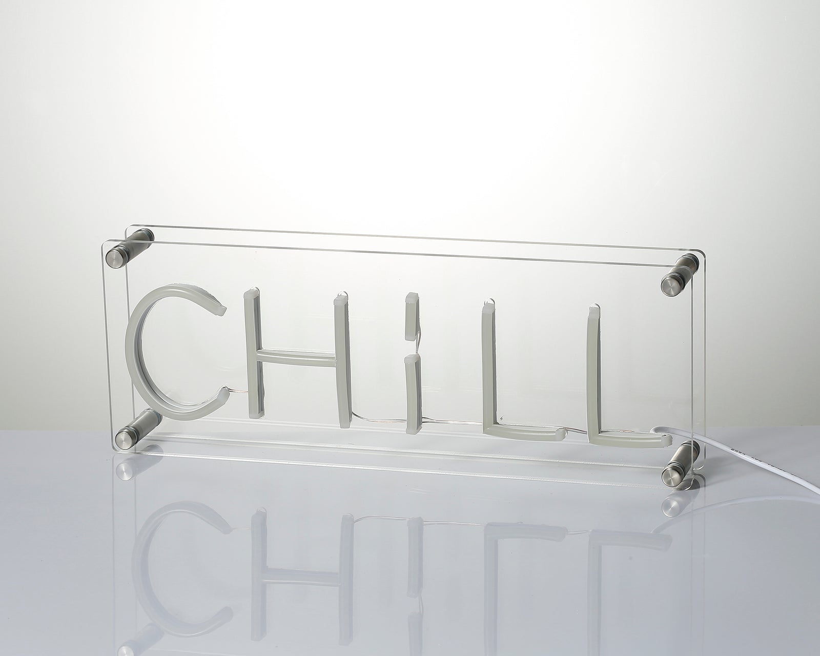 Close-up of the 'Chill' neon sign's glowing blue lettering on its clear acrylic base.
