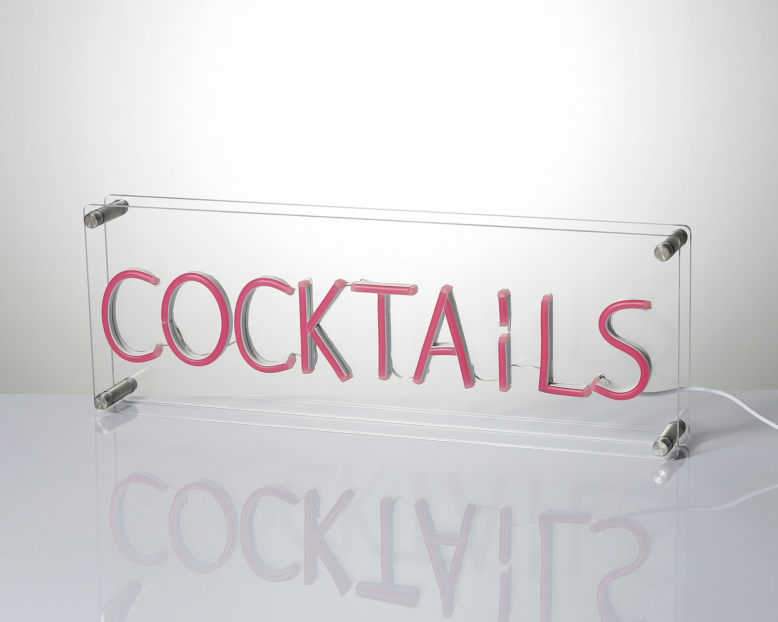 A close-up view of the back and side of the illuminated "Cocktails" neon sign, showing the clear acrylic casing and mounting.
