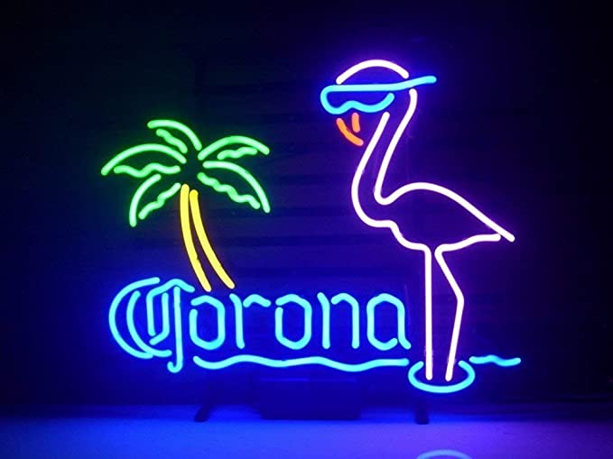 A glowing pink flamingo and green palm tree neon sign displayed indoors on a simple wooden surface, showing authentic tube details and real-world construction.