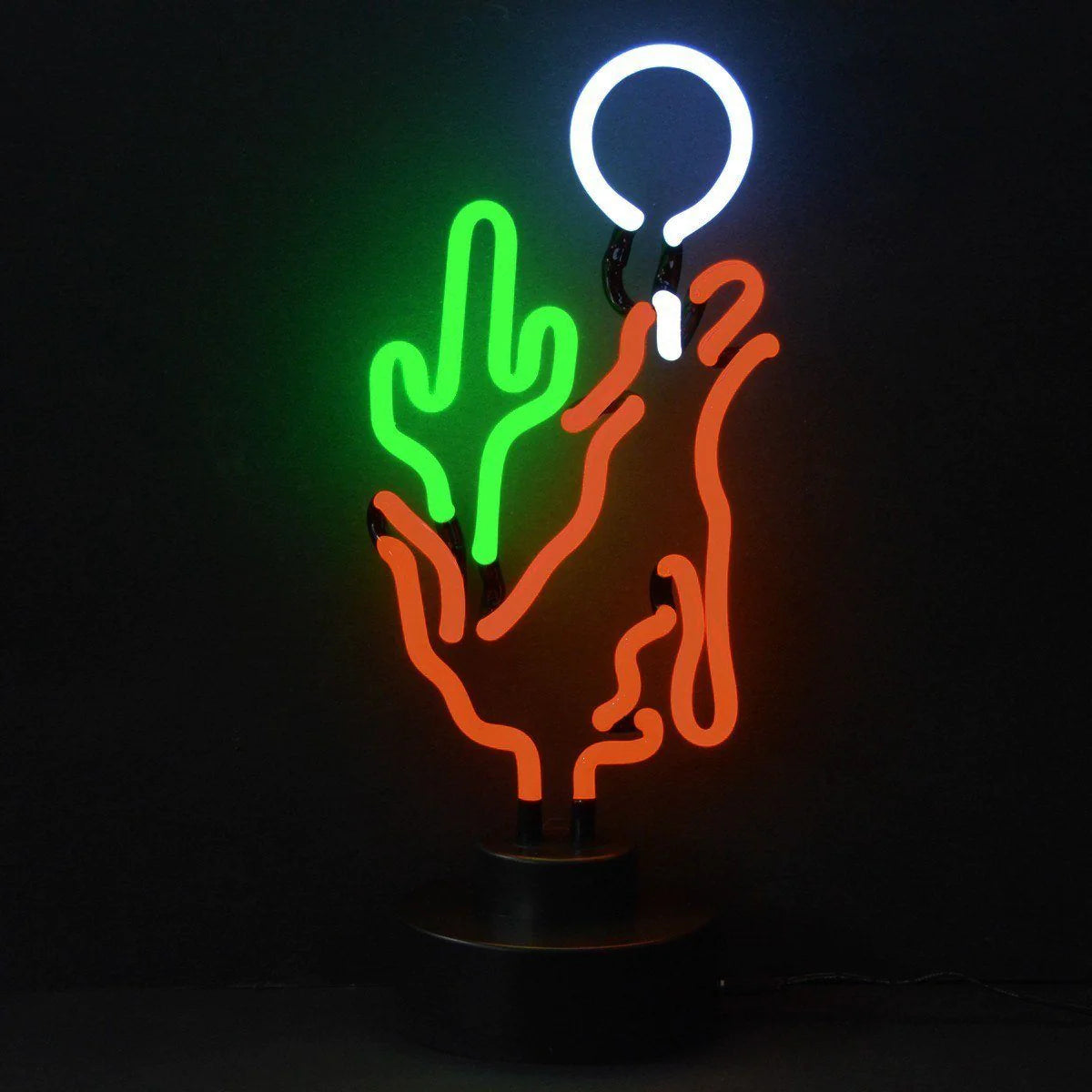 A close-up photograph of a fabricated traditional neon sign displaying a glowing coyote howling at a crescent moon next to a saguaro cactus, mounted against a plain black studio backdrop.