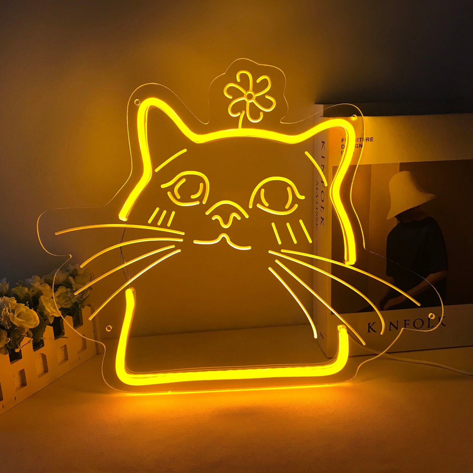 Cute cartoon cat face mini neon sign glowing brightly on a textured wall.
