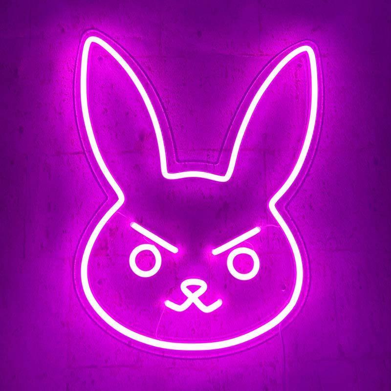 A glowing pink D.Va Bunny neon sign mounted on a concrete wall.