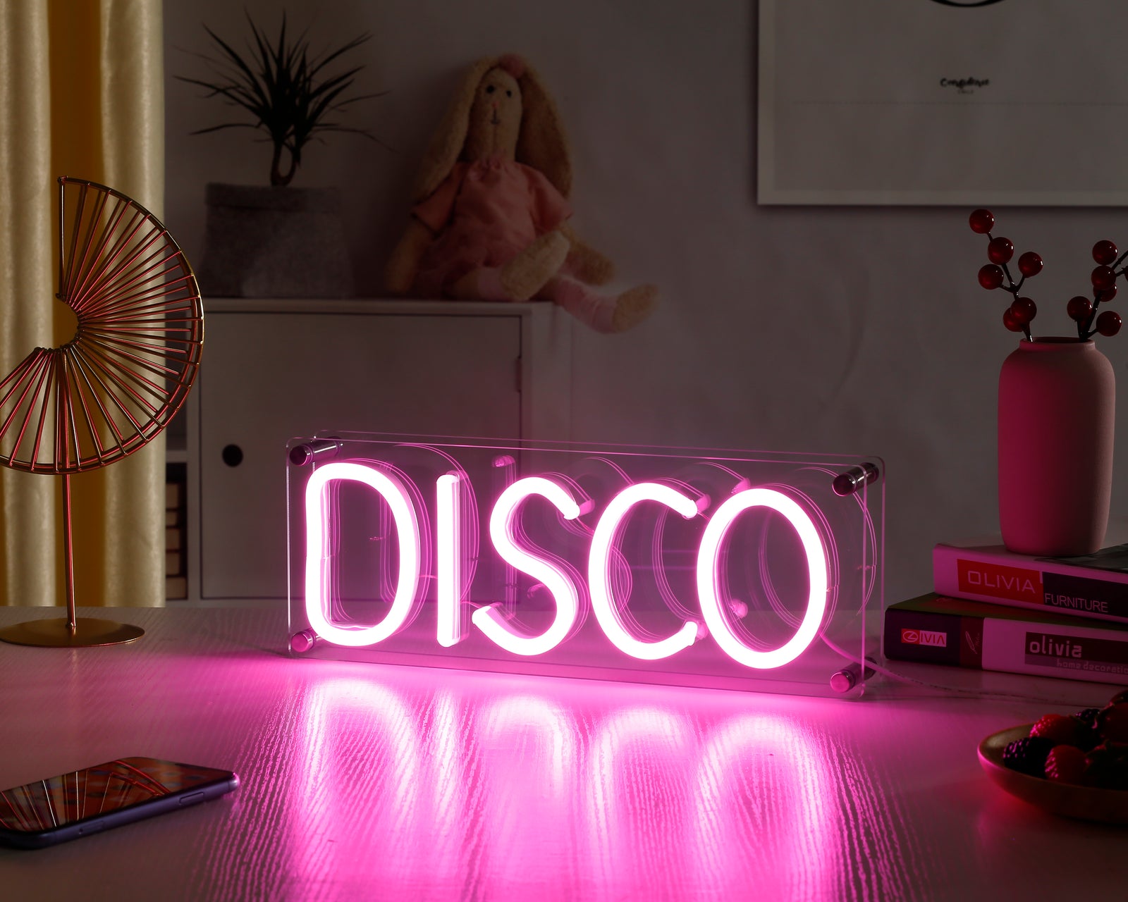 Glowing 'Disco' desk neon sign on a wooden surface