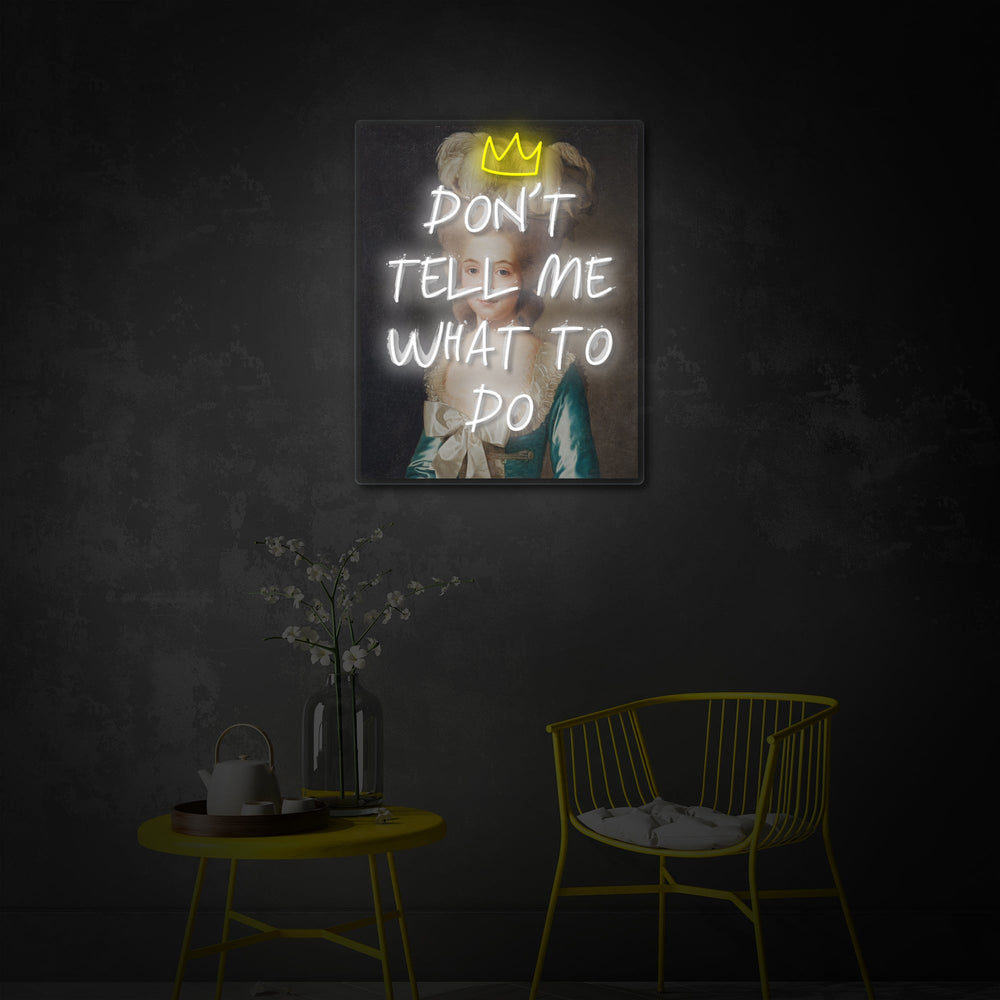 An neon sign featuring the quote "Don't Tell Me What To Do" hanging on a wall in a stylish living room setting.